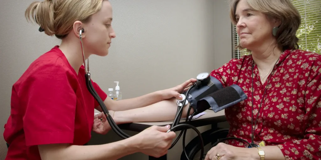 Ambulatory care nurse measuring patient’s blood pressure during outpatient check up An ambulatory care nurse checking a patient’s blood pressure in a clinical setting