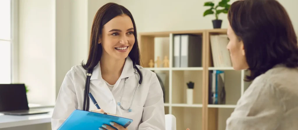 Healthcare professional consulting with a patient in a clinical office setting.