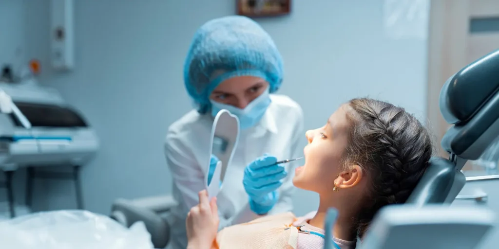 Pediatric dentist providing dental treatment to child - Best practices for managing pediatric dentist mailing lists for healthcare marketing