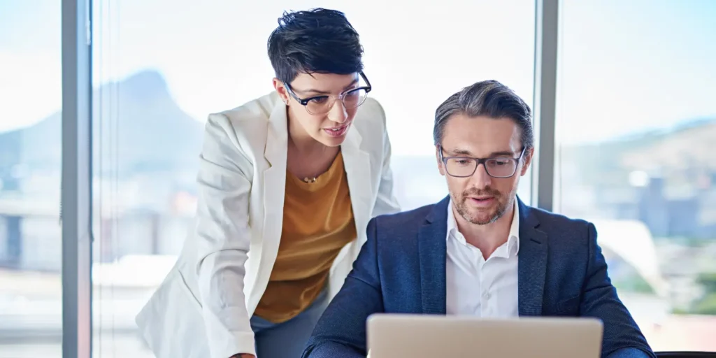 Two Chief Medical Officers collaborating in a bright office, highlighting the process of finding verified CMO email addresses for healthcare networking.