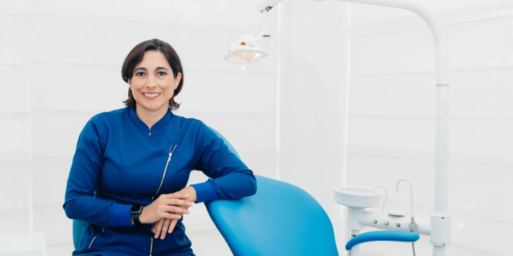 Female dental professional sitting in a clinic, ready to answer frequently asked questions about orthodontist email and contact lists in the USA