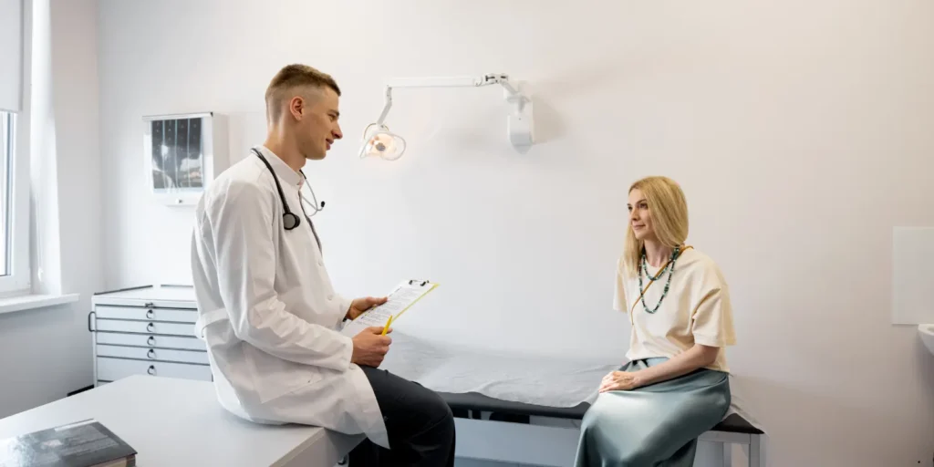 Doctor consulting a female patient in a modern medical office - Hepatologist Email List