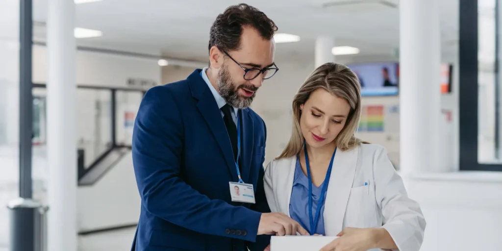 Hospital CEO reviewing reports with a healthcare professional, representing accurate Hospital CEO Email and Mailing List data.