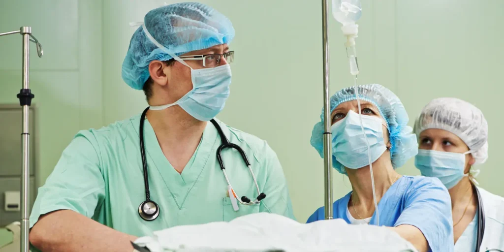 Anesthesiology team monitoring a patient during a medical procedure in an operating room.