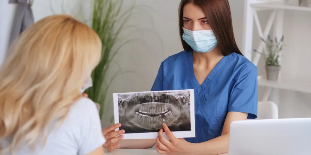 Two professionals discussing dental practice data on a laptop, representing the Orthodontist Email List in the USA
