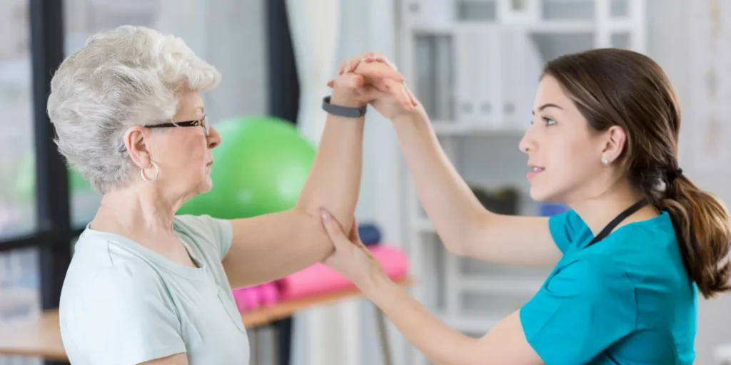 Physical therapist assisting elderly patient with therapy ball - Physical Therapist Email List marketing