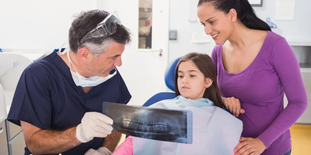 Pediatric dentist performing dental examination on child with parent present - Pediatric Dentist Email Lists for targeted healthcare marketing