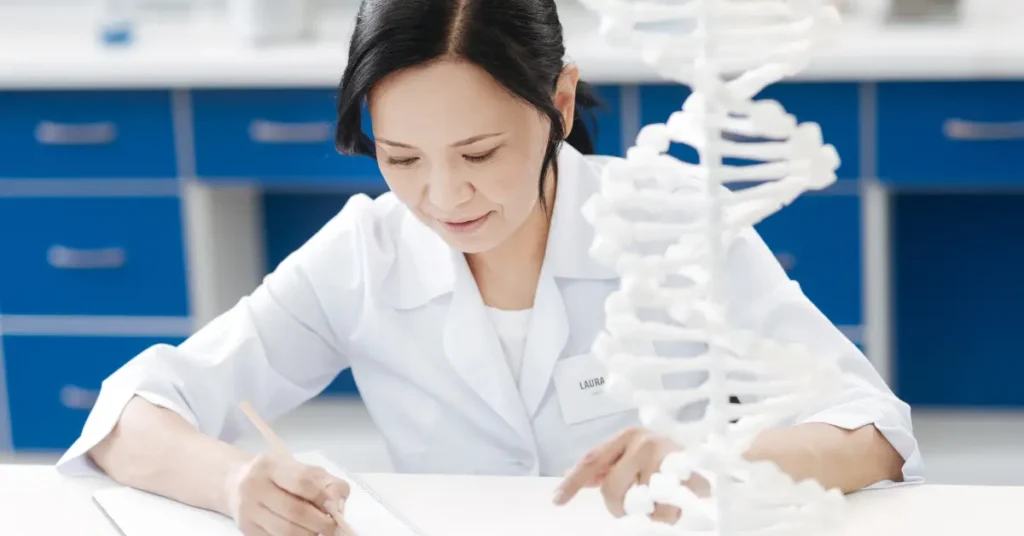 Female medical geneticist examining DNA model in laboratory for research and outreach purposes.